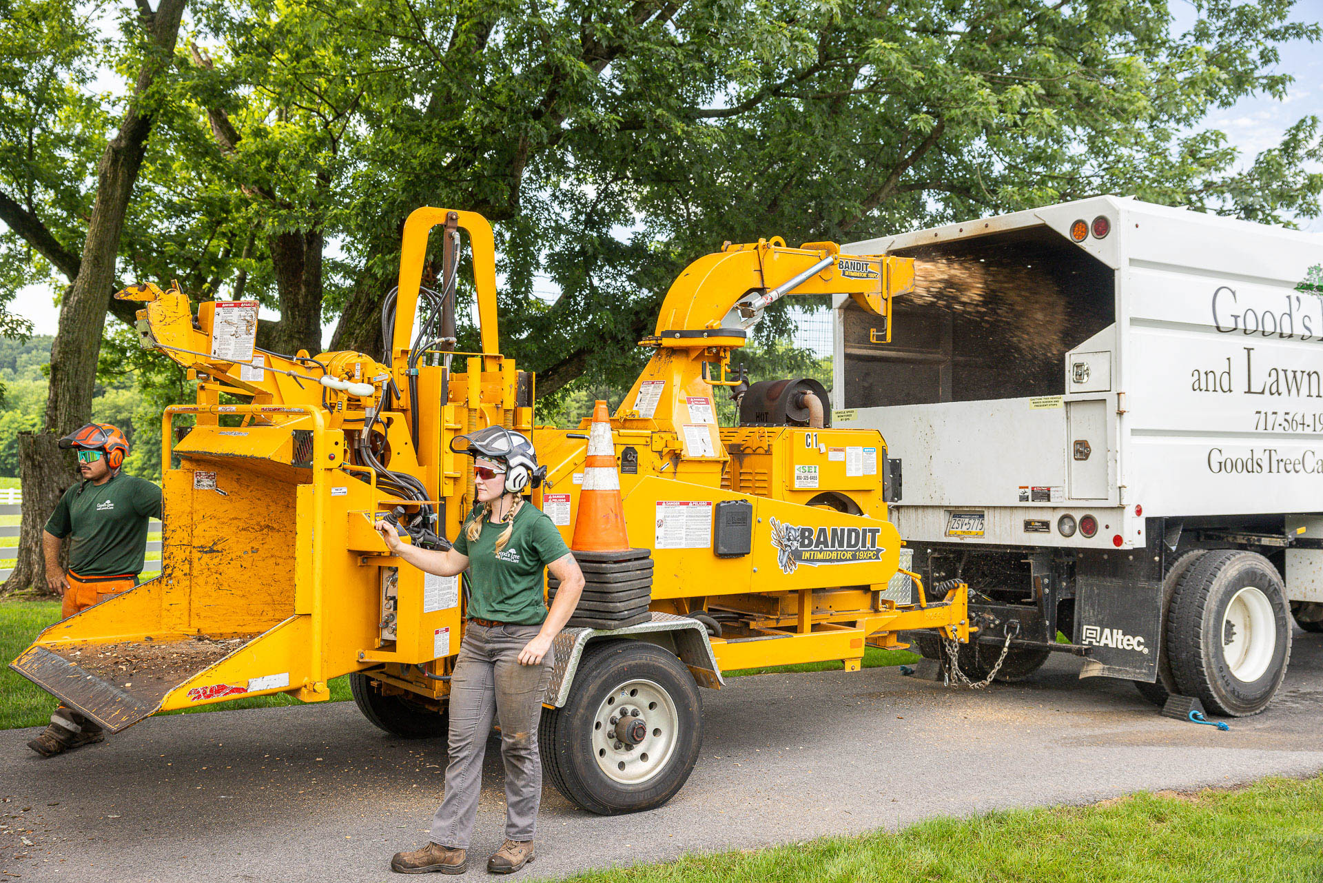 Crew clearing a storm-damaged tree with a wood chipper