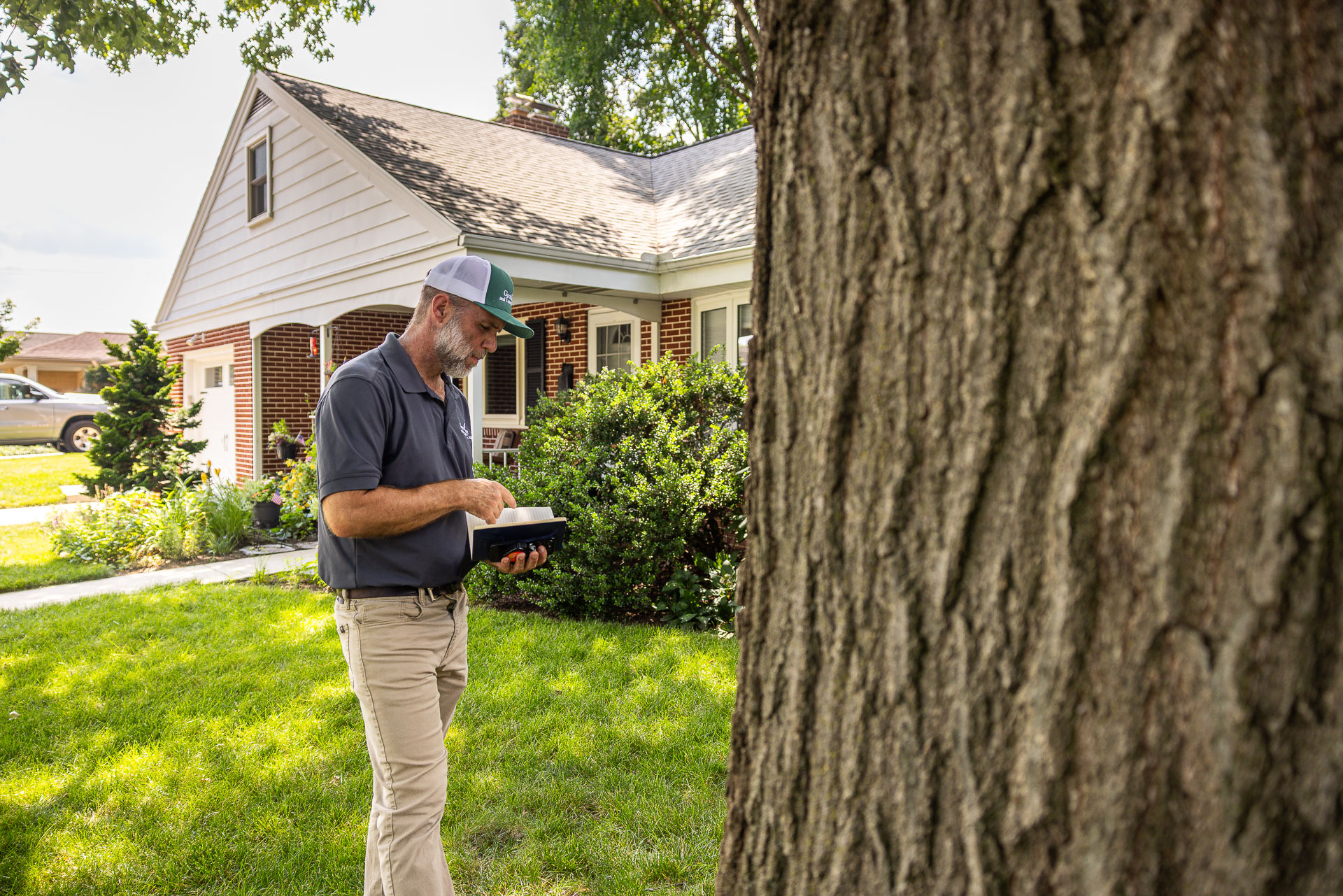 Good's technician assessing a tree and property line during a tick-prevention visit