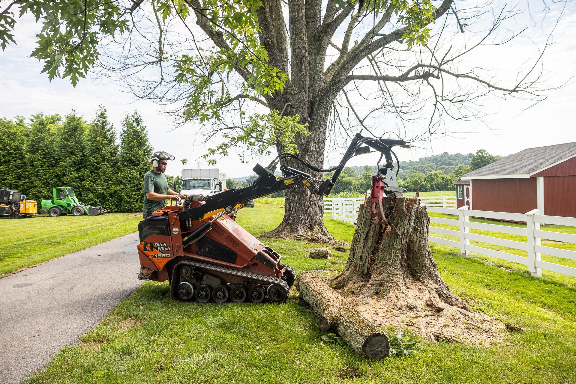 pulling off the top piece of a tree stump to prep for grinding